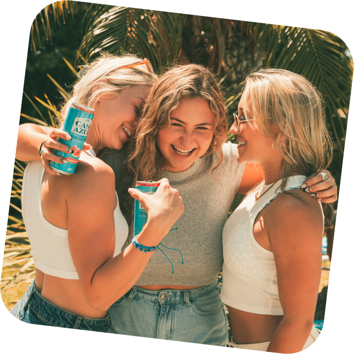 Three girls drinking Casa Azul tequila soda, laughing and hugging