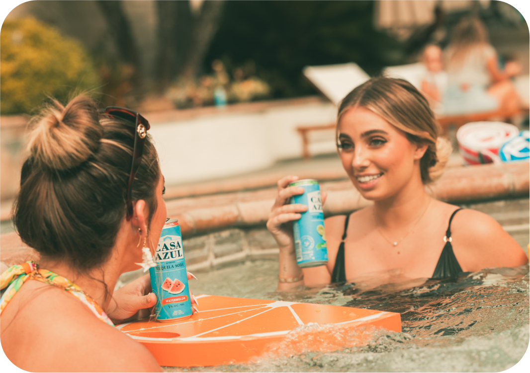 Two girls in hot tub drinking Casa Azul tequila soda